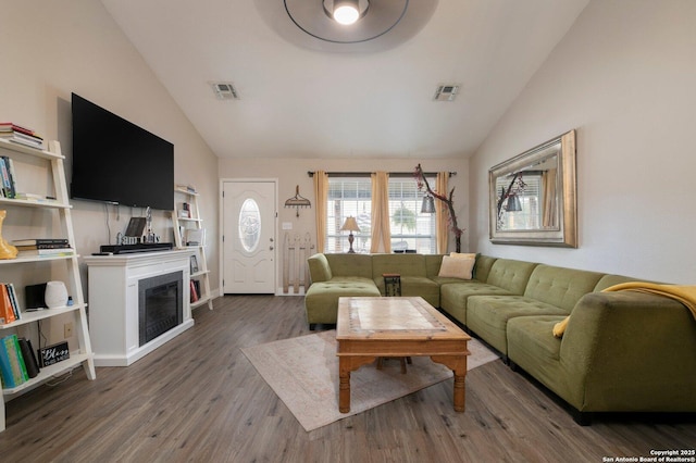 living room featuring high vaulted ceiling and dark hardwood / wood-style floors