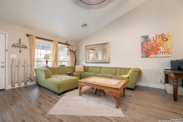 living room with hardwood / wood-style flooring and high vaulted ceiling