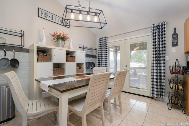 dining room with french doors, lofted ceiling, and light tile patterned floors