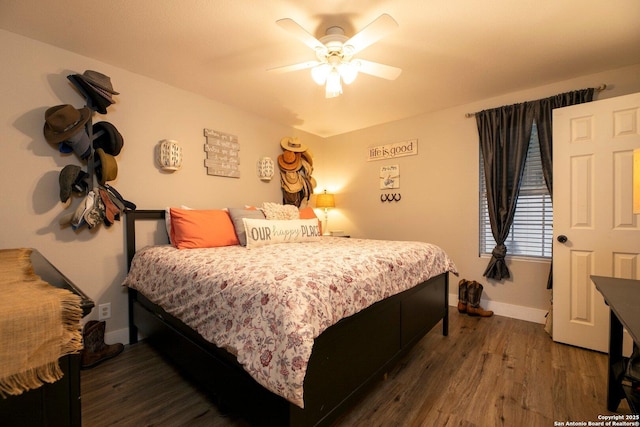 bedroom with dark hardwood / wood-style flooring and ceiling fan