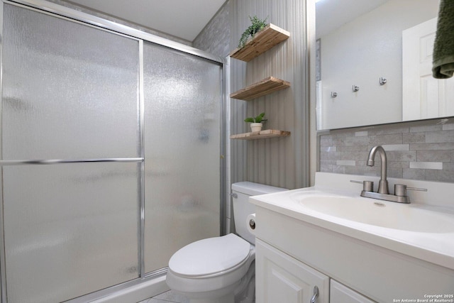 bathroom featuring vanity, decorative backsplash, toilet, and walk in shower