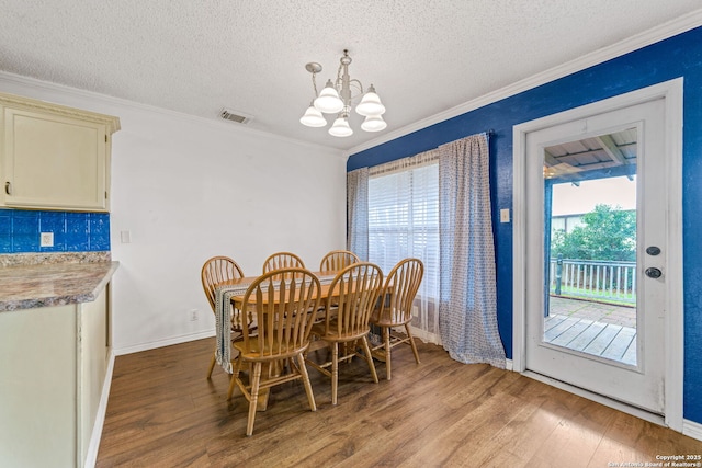 dining room featuring crown molding, light wood-type flooring, and a notable chandelier