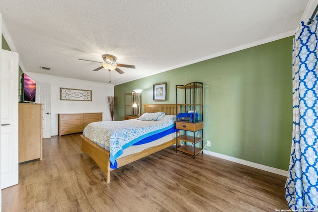 bedroom featuring hardwood / wood-style floors, crown molding, a textured ceiling, and ceiling fan