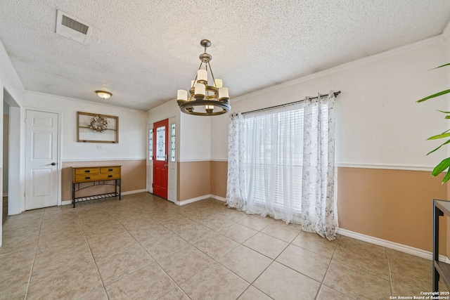 unfurnished dining area featuring crown molding, tile patterned floors, a chandelier, and a textured ceiling