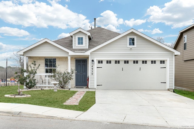 view of front of house featuring a garage, a front lawn, and a porch