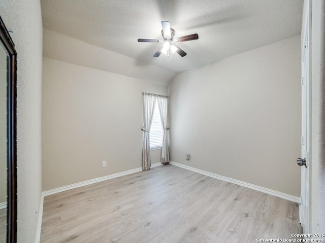 spare room featuring vaulted ceiling, ceiling fan, and light wood-type flooring