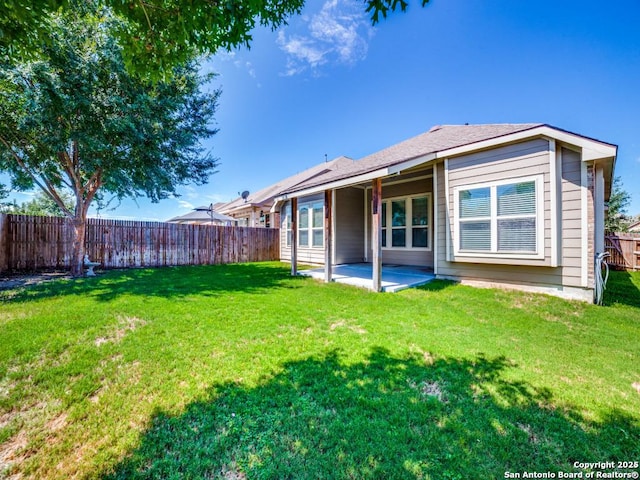 back of property with a yard and a patio area