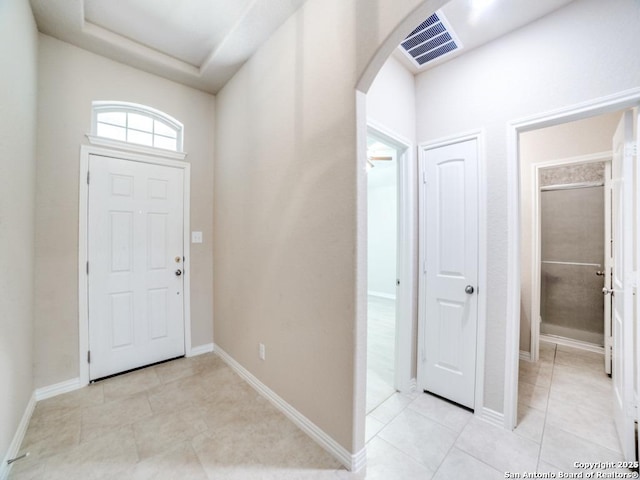 tiled entryway with a tray ceiling