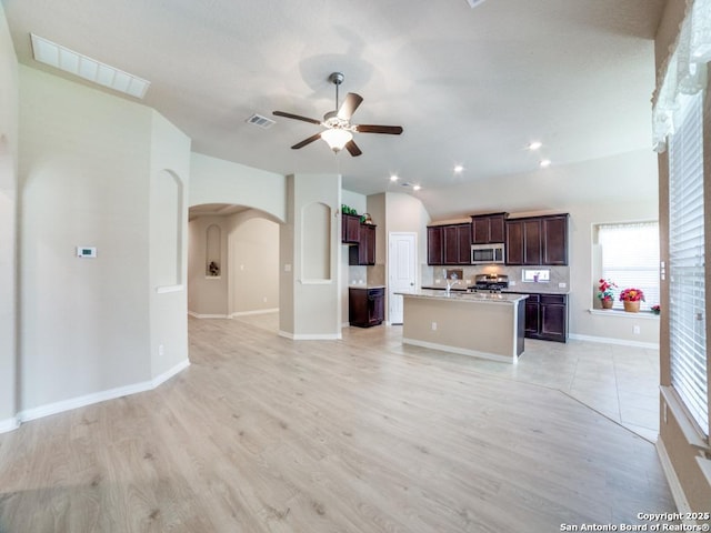 kitchen featuring a kitchen island with sink, range, ceiling fan, light hardwood / wood-style floors, and dark brown cabinets