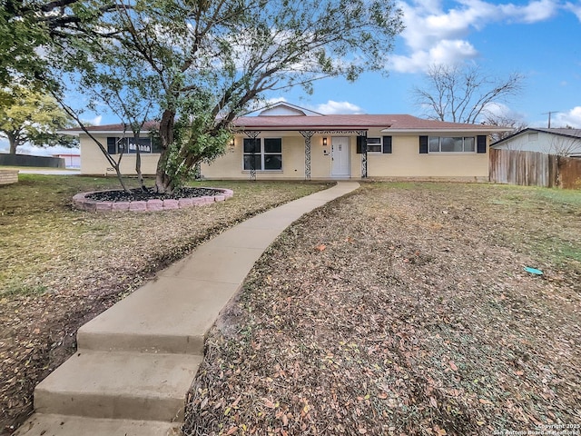 ranch-style house with fence and a front yard