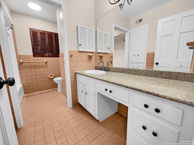 bathroom featuring tile patterned floors, toilet, tile walls, vanity, and radiator heating unit