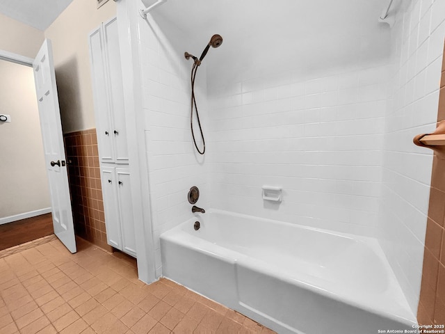 bathroom featuring tiled shower / bath, tile patterned flooring, and tile walls