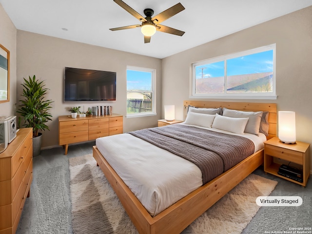 bedroom with ceiling fan and dark colored carpet