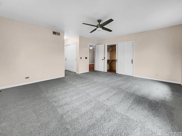 interior space with ceiling fan and dark colored carpet