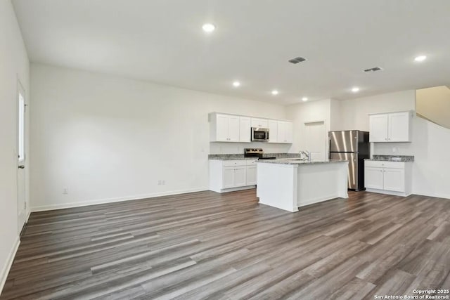 kitchen with hardwood / wood-style floors, sink, white cabinets, a kitchen island with sink, and stainless steel appliances