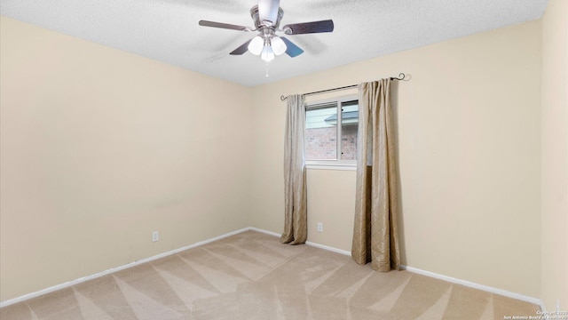 carpeted empty room featuring ceiling fan and a textured ceiling