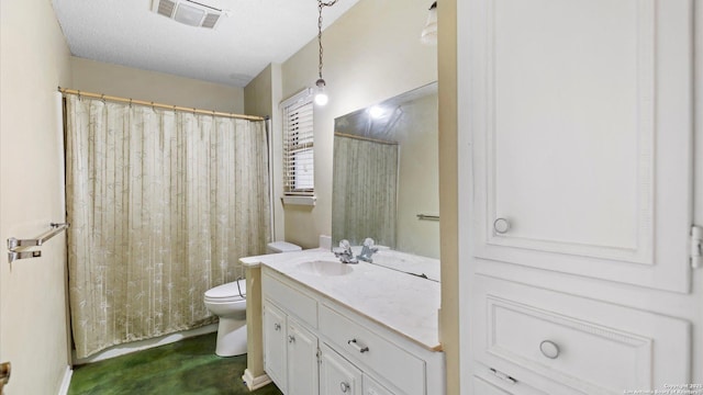 bathroom featuring vanity, a textured ceiling, and toilet