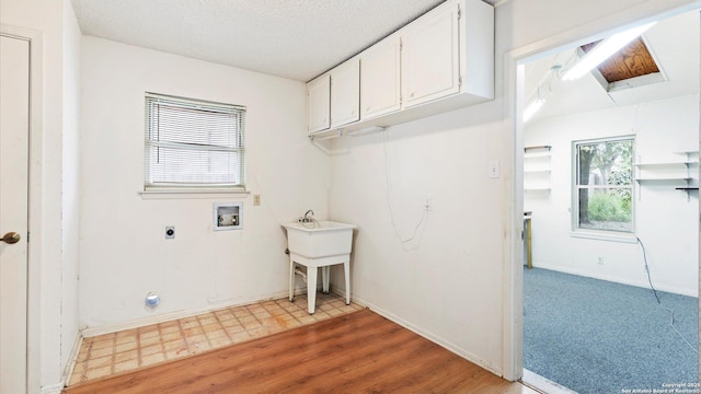 laundry room with cabinets, electric dryer hookup, hookup for a washing machine, and a wealth of natural light