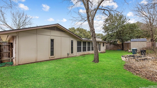 rear view of house featuring a storage shed and a lawn