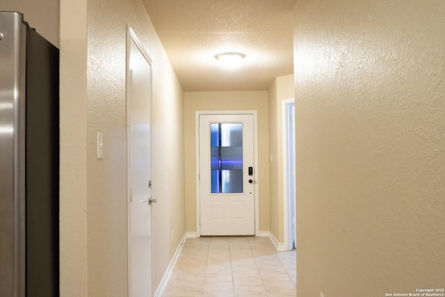 hallway with light tile patterned floors and a textured ceiling