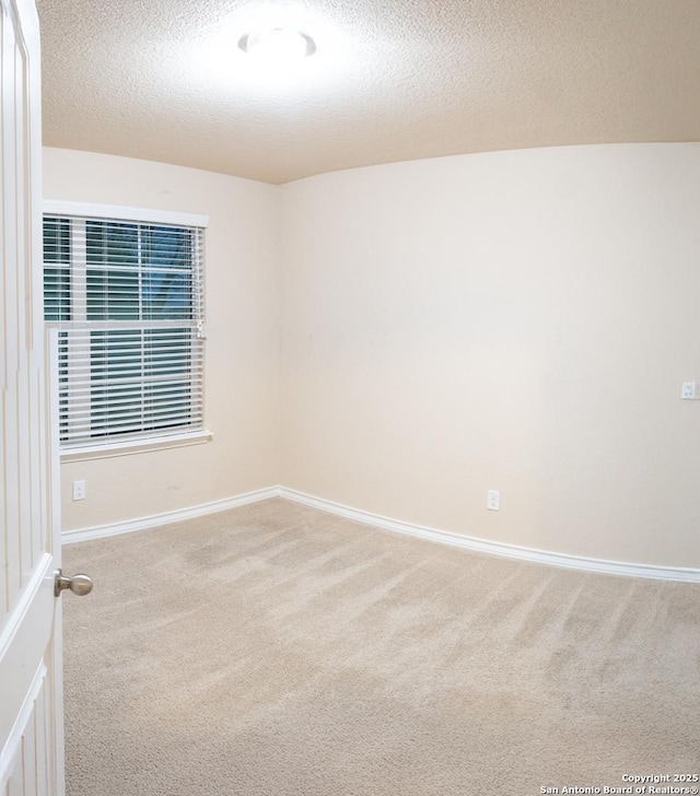 carpeted spare room featuring a textured ceiling