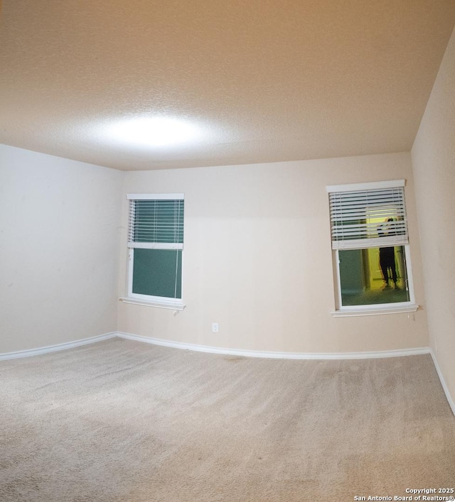 carpeted empty room featuring a textured ceiling