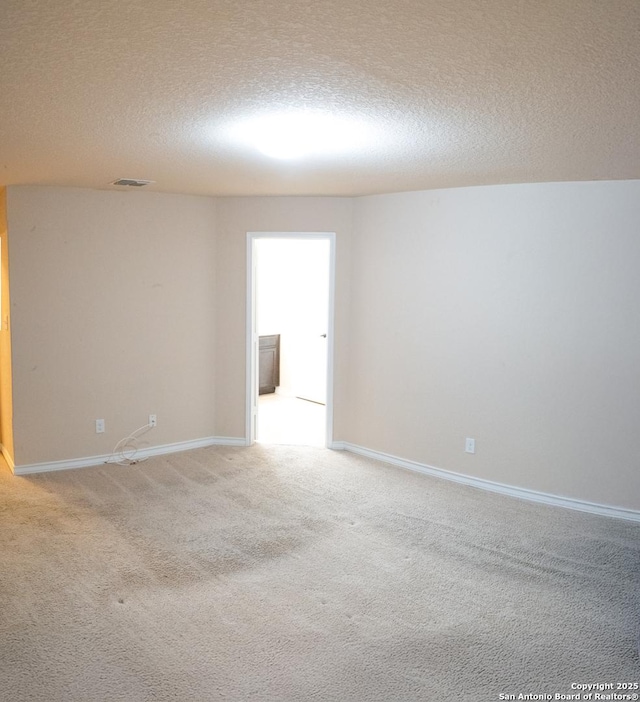 carpeted spare room featuring a textured ceiling