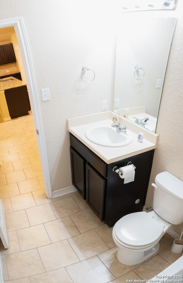 bathroom with tile patterned flooring, vanity, and toilet