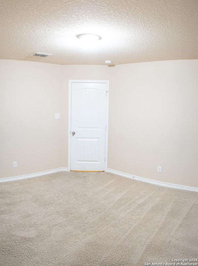 carpeted spare room with a textured ceiling