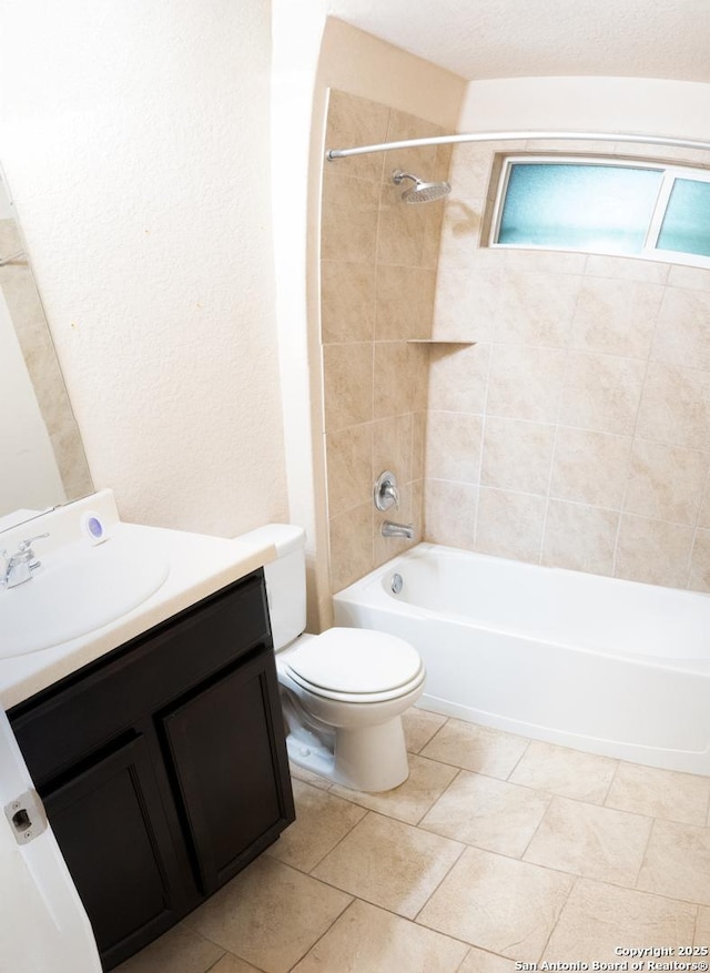 full bathroom featuring tiled shower / bath, vanity, and toilet