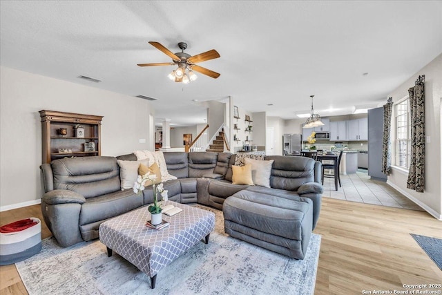 living room featuring light hardwood / wood-style flooring and ceiling fan