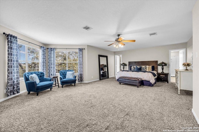 carpeted bedroom with ceiling fan and a textured ceiling