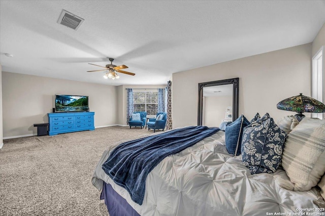 bedroom with ceiling fan, carpet flooring, and a textured ceiling