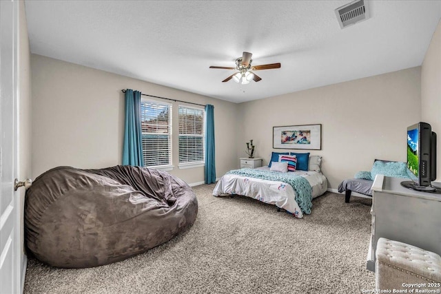 bedroom featuring ceiling fan, carpet floors, and a textured ceiling