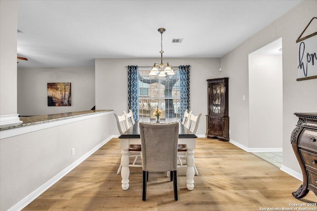 dining room with a chandelier and light hardwood / wood-style flooring