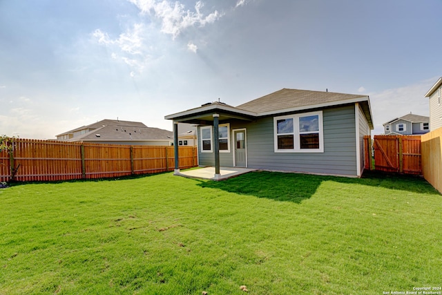 rear view of property with a patio and a yard