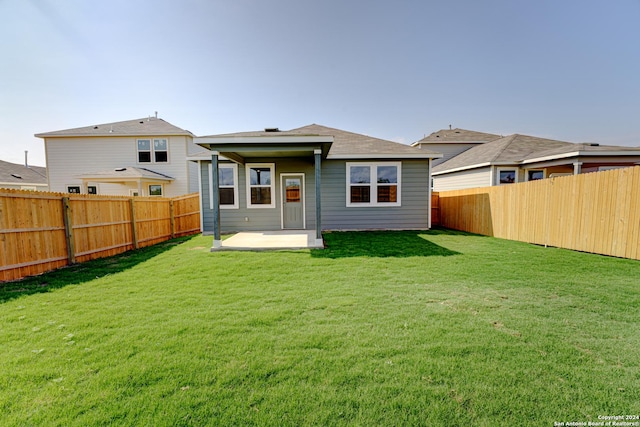 rear view of property with a lawn and a patio area