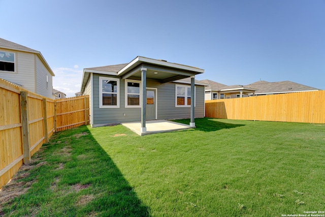 rear view of property featuring a patio and a lawn