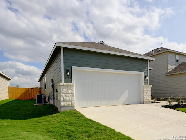 view of side of property with a yard, a garage, and central air condition unit