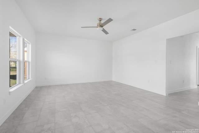 empty room with ceiling fan and a wealth of natural light