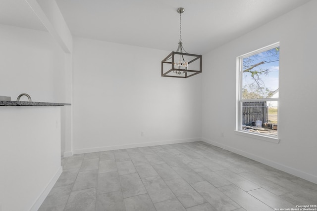 unfurnished dining area featuring a chandelier