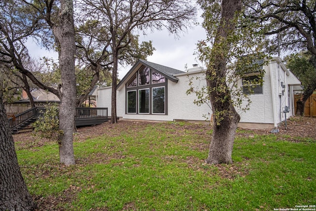 rear view of house with a deck and a lawn