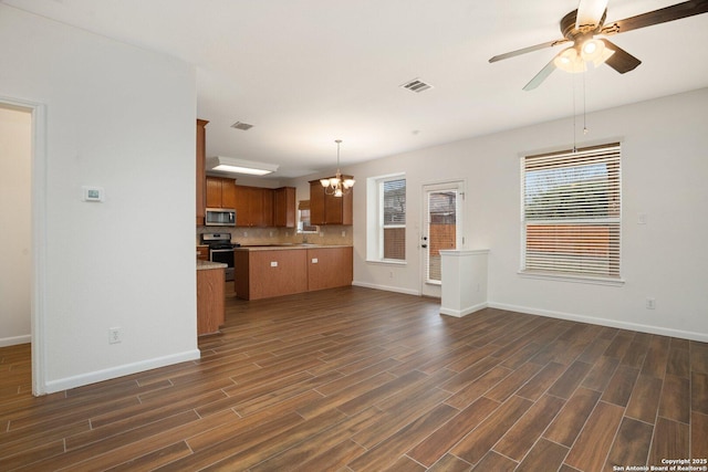 unfurnished living room with sink, dark hardwood / wood-style floors, and ceiling fan with notable chandelier