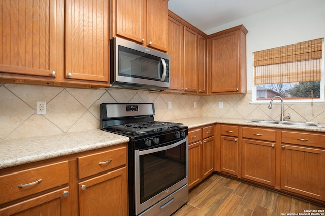 kitchen with tasteful backsplash, appliances with stainless steel finishes, dark hardwood / wood-style floors, and sink