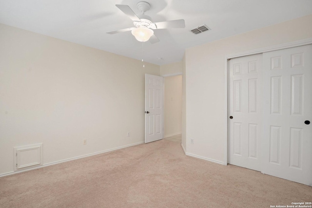 unfurnished bedroom with ceiling fan, light colored carpet, and a closet