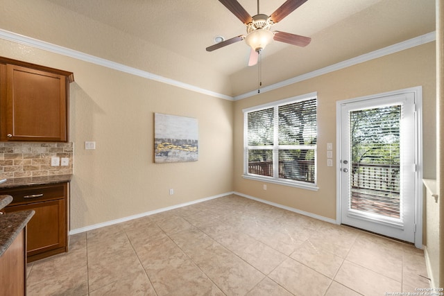 unfurnished dining area featuring ceiling fan, ornamental molding, and light tile patterned floors