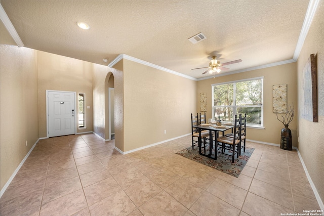 dining space featuring ceiling fan, ornamental molding, a textured ceiling, and light tile patterned floors