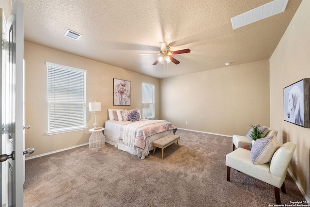 bedroom with ceiling fan, light carpet, and a textured ceiling