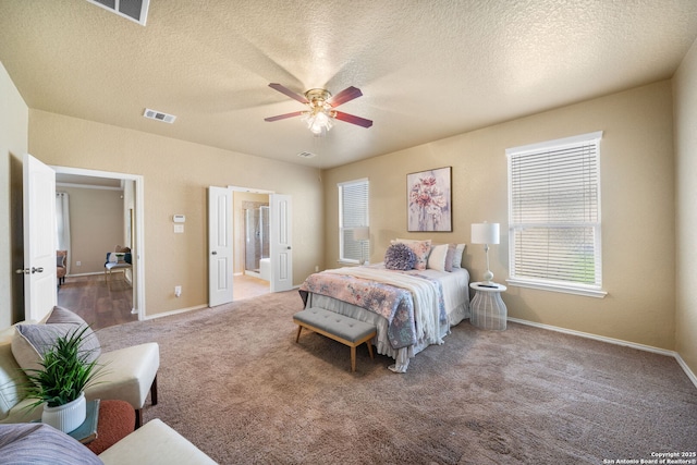 carpeted bedroom featuring ceiling fan, connected bathroom, and a textured ceiling