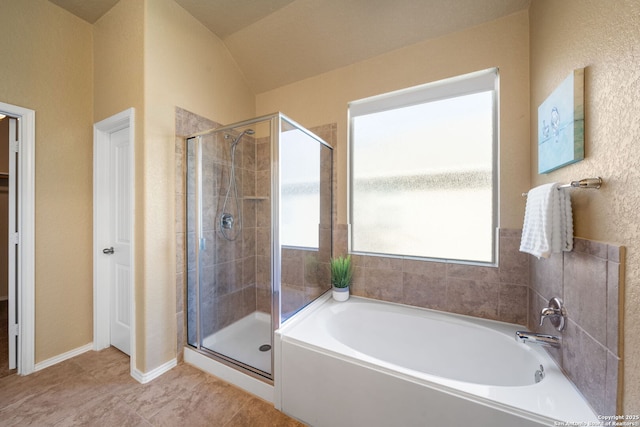 bathroom with tile patterned flooring, vaulted ceiling, and separate shower and tub